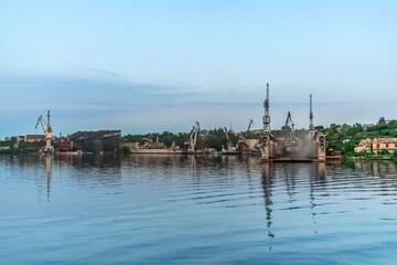 Mykolaiv, Ukraine - July 25, 2020: Industrial coastline with the Mykolayiv Shipyard on the Inhul River on a summer evening. Urban panorama of Ukrainian town