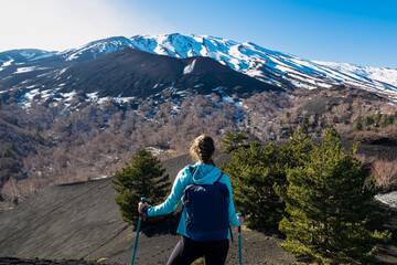 Tourist woman hiking on volcanic landscape of volcano mount Etna, in Sicily, Italy, Europe. Pine...