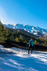 Tourist woman hiking on volcanic landscape of volcano mount Etna, in Sicily, Italy, Europe. Pine...