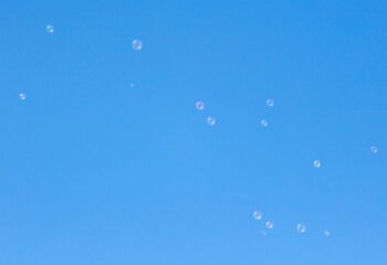 Soap bubbles fly against the sky.