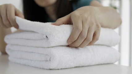 Woman putting fresh towels on table closeup
