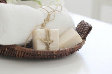 Soap and white towel rolls on the basket. health spa concept for products and backgrounds
