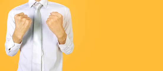 business man in white work clothes on a yellow background,clenched fists to encourage work