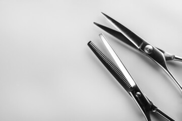 Two pairs of hairdressing scissors for hair cutting on gray background