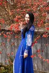 Beautiful slavonic girl with long brunette hair in blue dress. Traditional clothes of Ukrainian region. 