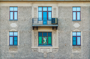 Balcony and several windows in a row on the facade of the urban historic apartment building front view, Saint Petersburg, Russia

