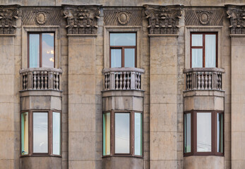 Several windows in a row on the facade of the urban historic apartment building front view, Saint Petersburg, Russia
