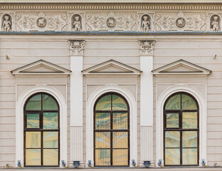 Three windows in a row on the facade of the urban historic apartment building front view, Saint Petersburg, Russia
