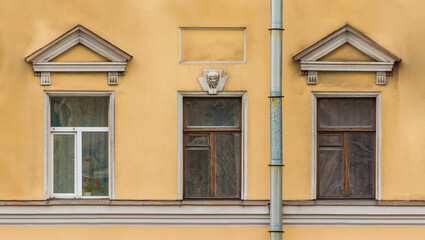 Fototapeta premium Three windows in a row on the facade of the urban historic apartment building front view, Saint Petersburg, Russia 