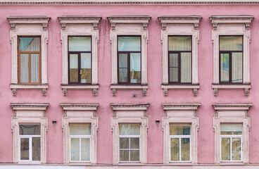 Fototapeta premium Many windows in a row on the facade of the urban historic apartment building front view, Saint Petersburg, Russia 