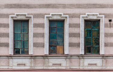 Three windows in a row on the facade of the urban historic apartment building front view, Saint Petersburg, Russia
