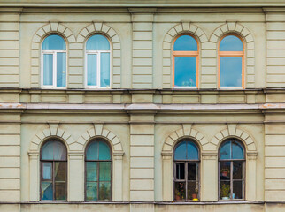 Several windows in a row on the facade of the urban historic apartment building front view, Saint Petersburg, Russia
