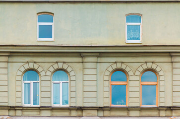 Fototapeta na wymiar Several windows in a row on the facade of the urban historic apartment building front view, Saint Petersburg, Russia 