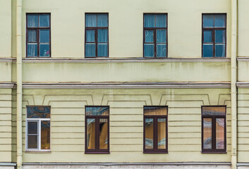 Several windows in a row on the facade of the urban historic apartment building front view, Saint Petersburg, Russia
