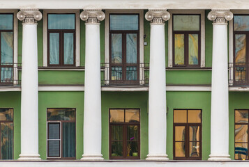 Obraz premium Columns and several windows in a row on the facade of the urban historic apartment building front view, Saint Petersburg, Russia 