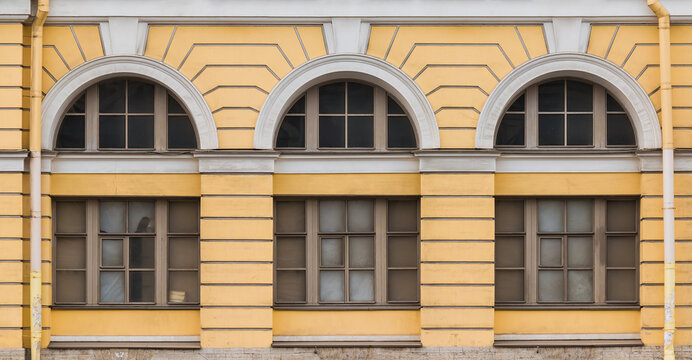 Three windows in a row on the facade of the urban historic apartment building front view, Saint Petersburg, Russia
