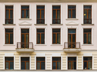 Two balconies and many windows in a row on the facade of the modern urban apartment building front view, Krasnaya Polyana, Sochi, Krasnodar Krai, Russia
