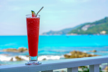 Watermelon shake with metal straw at the blue beach.