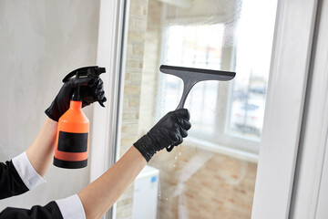 Professional Cleaning service company employee in rubber gloves remove dirt from windows using mop, close up