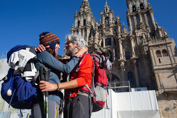 A couple of pilgrims celebrate in front of the cathedral of Santiago that they have reached the end...