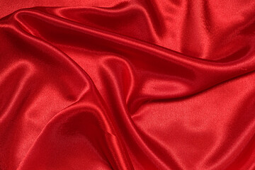 Fototapeta na wymiar Texture of crumpled red satin fabric, beautiful pattern.