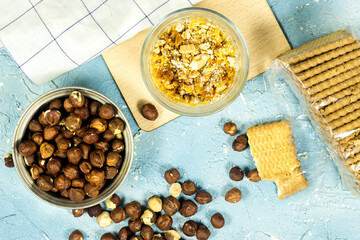pudding or cheesecake dessert in glass, delicious and simple with  biscuit and cream and Hazelnuts in a metal bowl on blue background