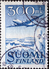 Finland - circa 1950: a postage stamp from Finland, showing an Aircraft Douglas DC-6 over Winter Landscape