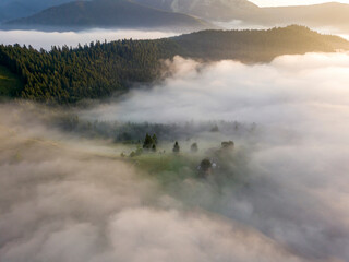 Obraz na płótnie Canvas Sunrise over the fog in the Ukrainian Carpathians. Aerial drone view.