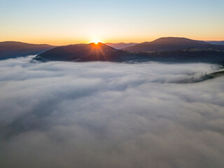 Fototapeta premium Sunrise over the fog in the Ukrainian Carpathians. Aerial drone view.
