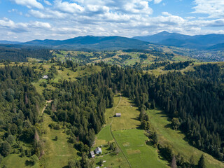 Green mountains of Ukrainian Carpathians in summer. Coniferous trees on the slopes. Aerial drone view.