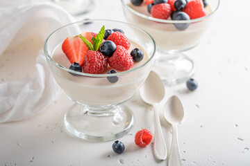 Vanilla and sweet Panna Cotta with raspberries and blueberries.