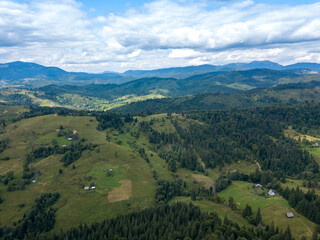 Green mountains of Ukrainian Carpathians in summer. Coniferous trees on the slopes. Aerial drone view.