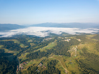 High flight in the mountains of the Ukrainian Carpathians. Fog in the valley. Aerial drone view.