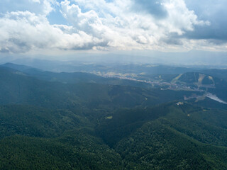 Fototapeta premium Green mountains of Ukrainian Carpathians in summer. Sunny day, rare clouds. Aerial drone view.