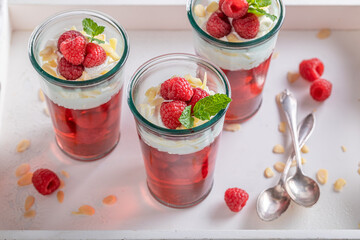 Sweet red jelly with raw raspberries and whipped cream.