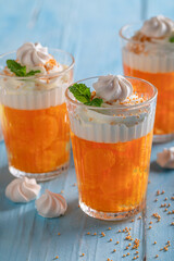 Tasty and homemade orange jelly with small mandarins and cream.