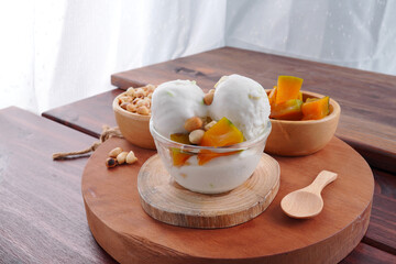 Traditional coconut milk ice cream topped with milk and roasted peanuts.