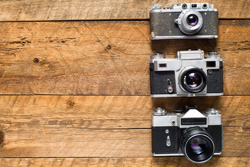 Old retro cameras on vintage wooden boards abstract background