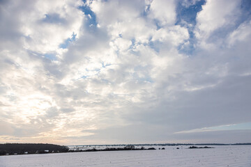 Obraz premium Natural sunset sunrise over field or meadow. The color of the sky over the winter snowy ground. Landscape under a picturesque sky at sunset. Dawn of the sun.