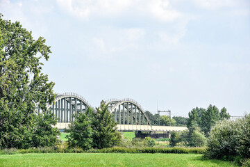 Fototapeta na wymiar View of the railway bridge over the Maas, near Ravenstein. Netherlands, Holland, Europe