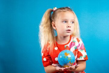 The girl is holding a globe in her hands. The concept of children's dream, the future of the...