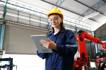 Fototapeta na wymiar Professional young industrial factory woman employee working with machine parts putting, checking and testing industrial robot arms in large Electric electronics manufacturing plant factory.