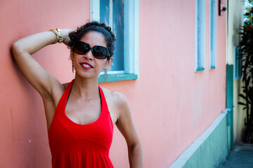 Portrait of a woman wearing red clothes on the street in bright sunny day.