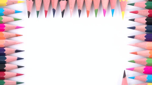 Frame made of colorful wooden pencils on a white background. Stop motion animation.