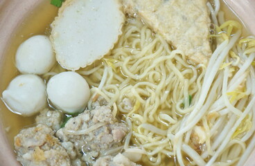 egg yellow noodles topping chop boiled pork and fish ball in soup on bowl