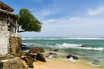 Fototapeta premium Rocky tropical beach with house, rural Sri Lanka