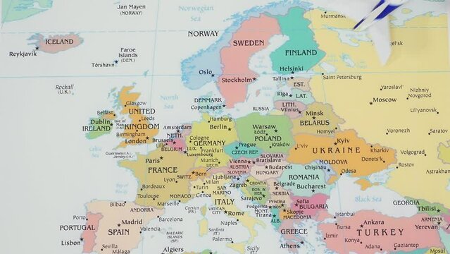 Toy plane travels over different countries on a map of Europe. Concept of international flights, tourism. Stop motion animation.