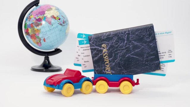Spinning globe and a colorful toy car with a passport and tickets in the trailer, concept of car international travel. Stop motion animation.