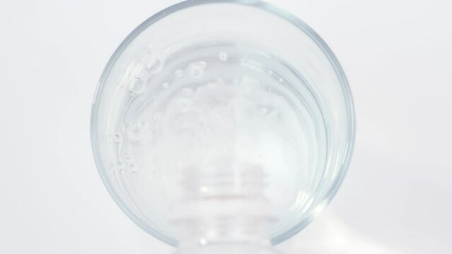 Pouring water from a bottle into a glass and throwing soluble effervescent tablet of medicament or vitamin