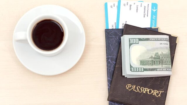 Passports, plane tickets, money and a cup of coffee appear on table. Stop motion animation.